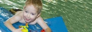 Little boy in swimming pool on a float | aquatic therapy