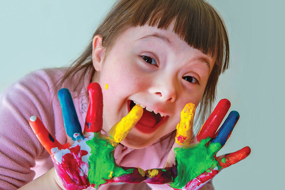 Smiling girl with finger paints